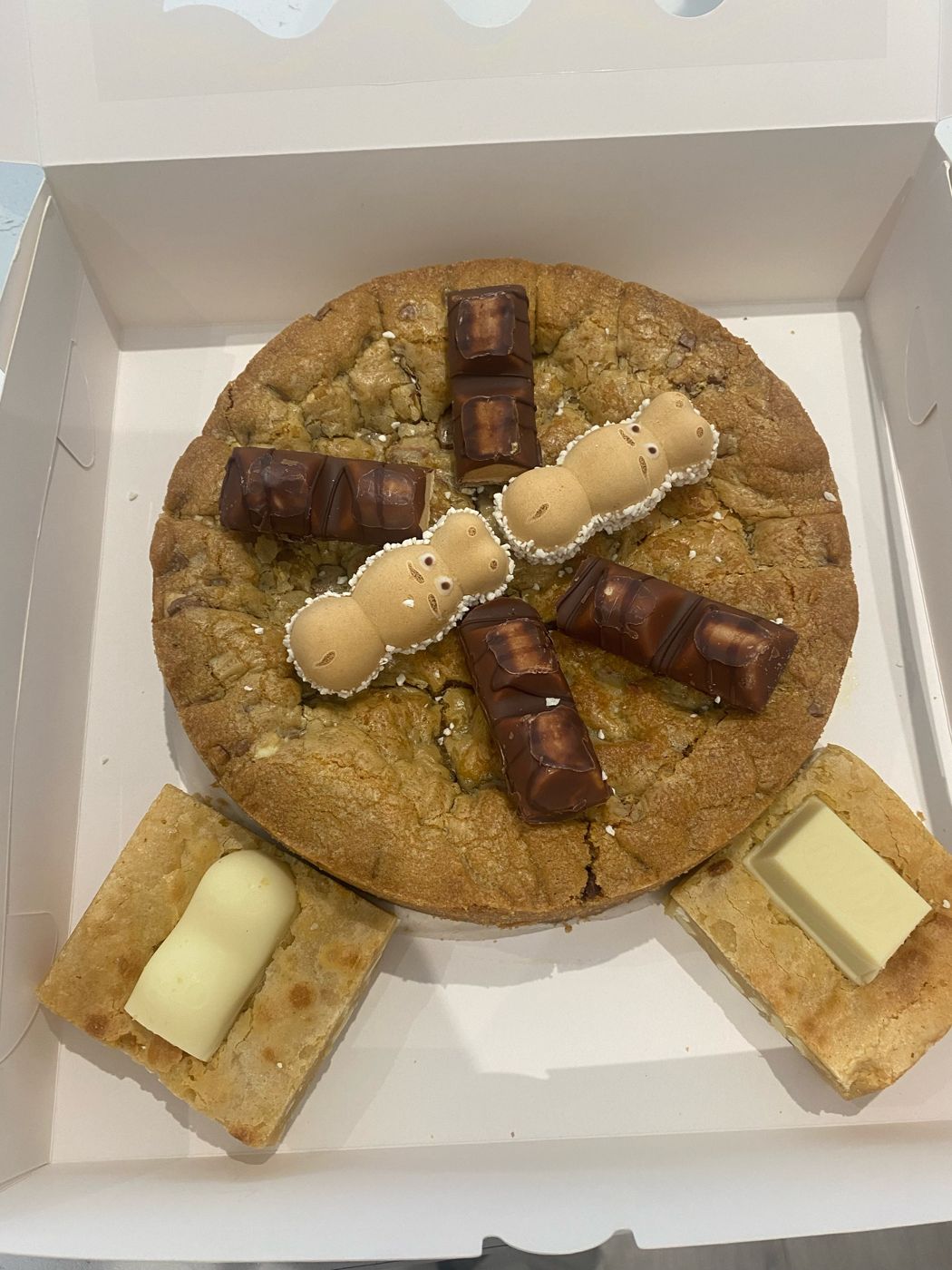 A giant cookie pie topped with chocolate pieces