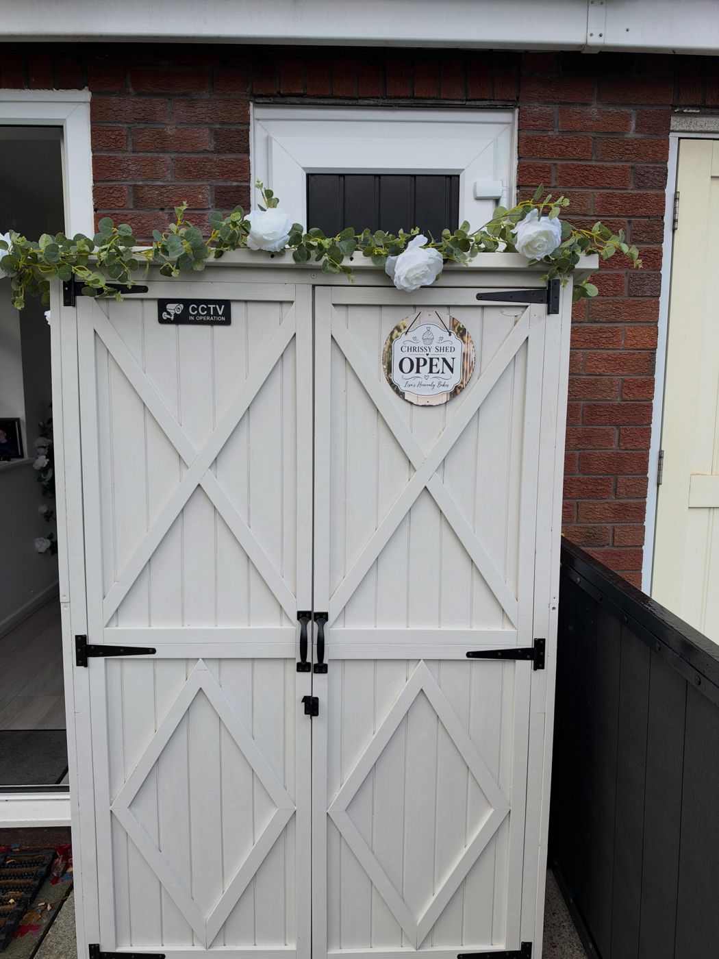 The white wooden Chrissy Shed with its doors closed